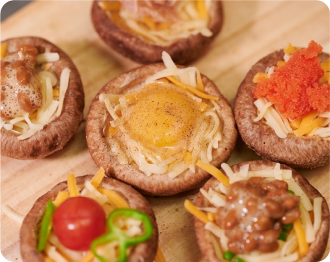 しいたけの料理写真。5つのしいたけにチーズや野菜がトッピングされている。